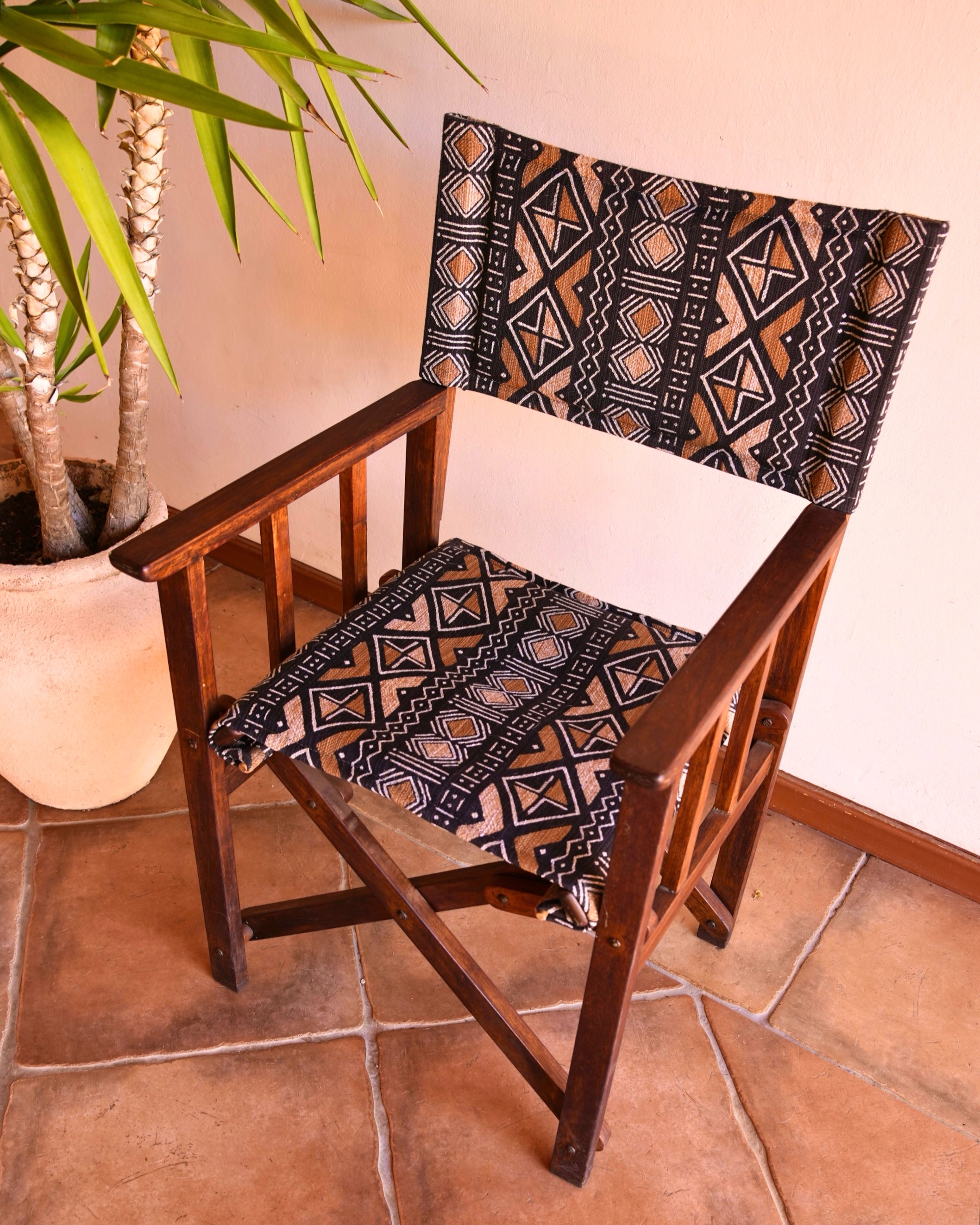 Dark wood director's chair upholstered in black and tan African mudcloth pattern fabric